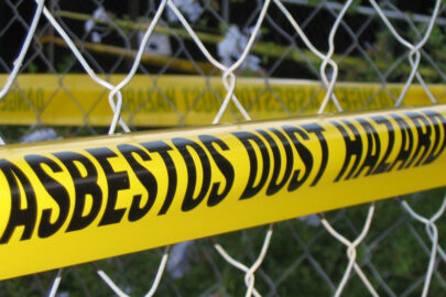 Caution tape with 'ASBESTOS DUST HAZARD' text as a warning in a restricted area