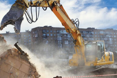 Excavator demolishing a building, showcasing the need for demolition safety permits