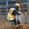 Construction worker with safety harness working at heights on a building site