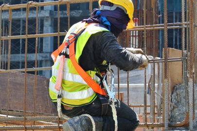 Construction worker with safety harness working at heights on a building site