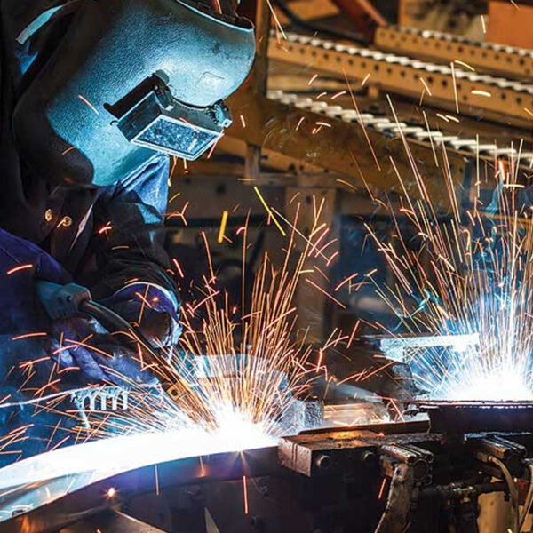 Welder performing hot work with sparks flying, under safety permit regulations