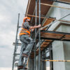 Construction worker securing scaffolding to ensure safety compliance