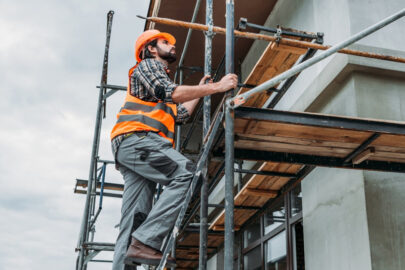 Construction worker securing scaffolding to ensure safety compliance